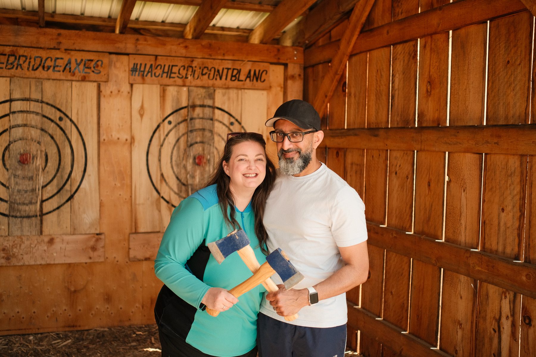 A couple holding axes at the range