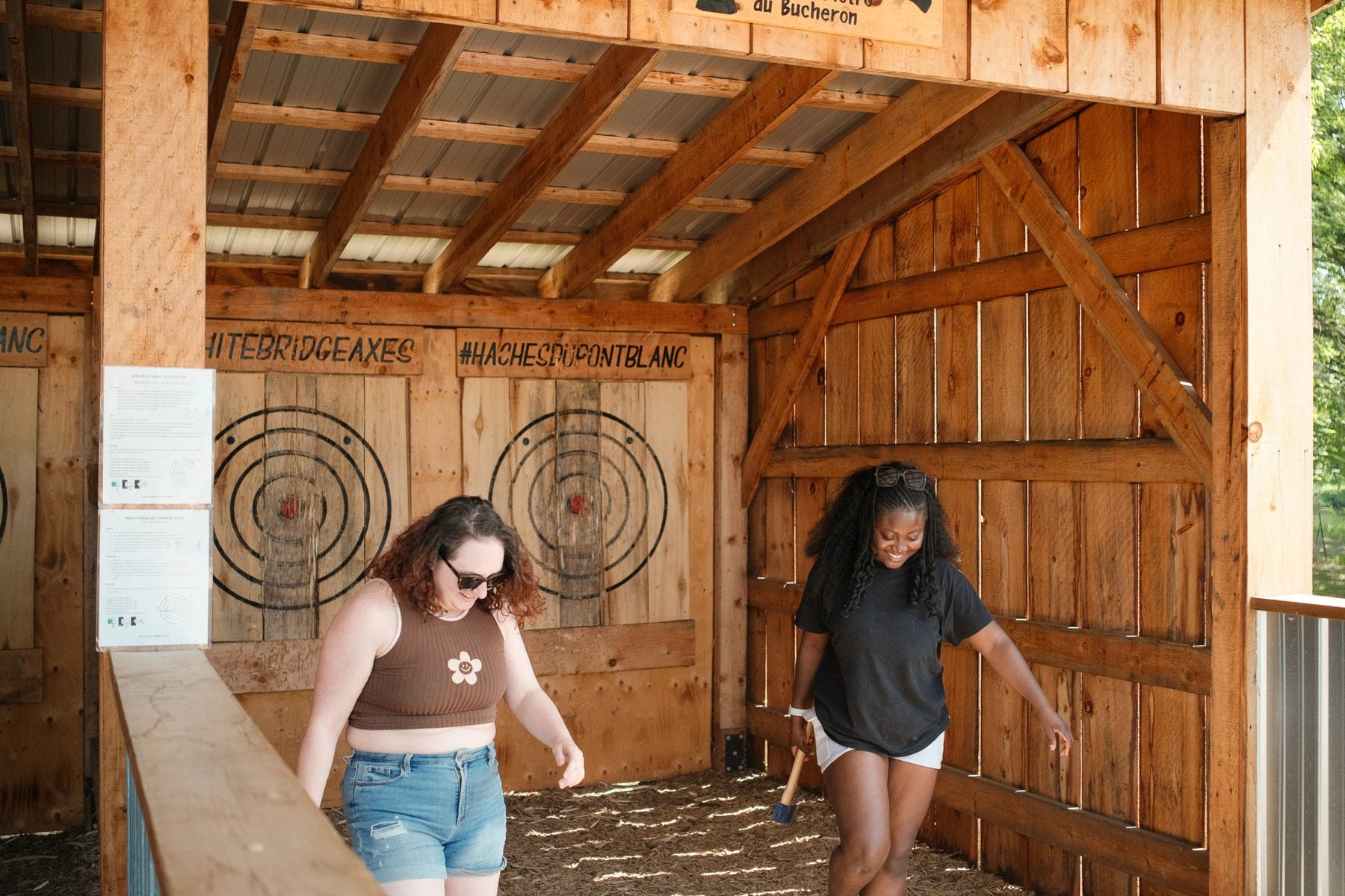 Two guests laughing in the axe throwing range