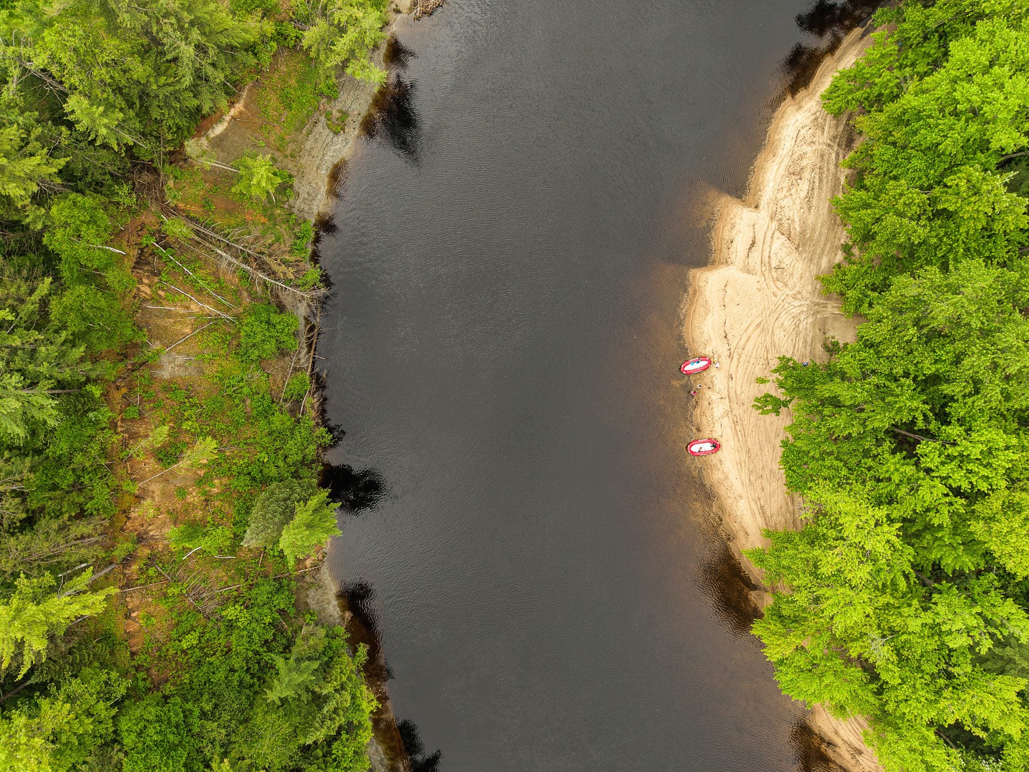 Aerial view of the Coulonge River winding through forest at Camping Pont Blanc